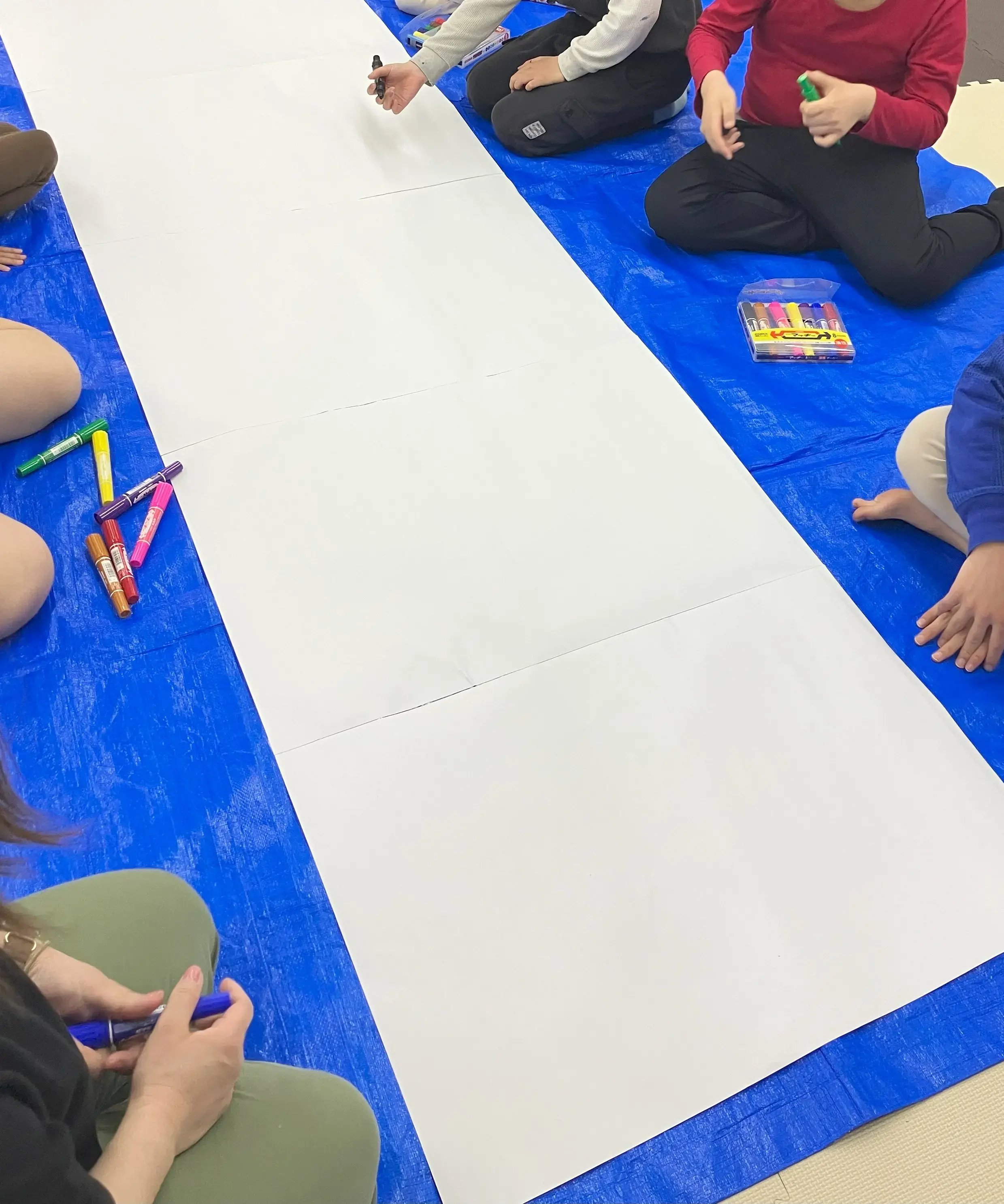 大きな模造紙に絵をかいている様子